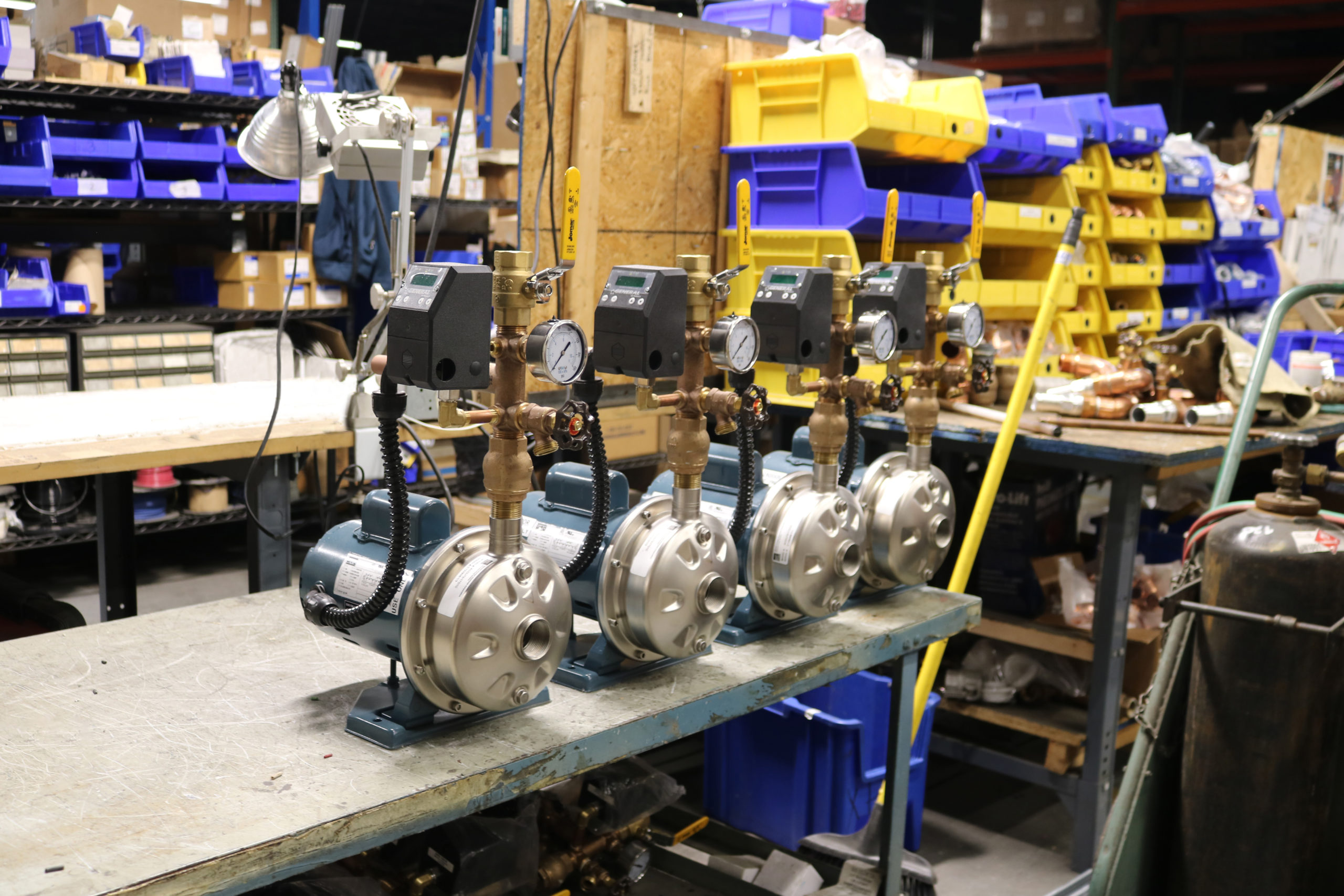 several water pumps are lined up on a table in a warehouse