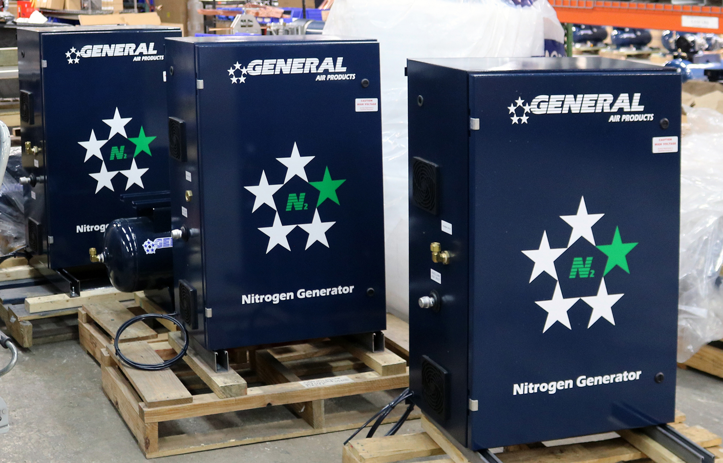 three nitrogen generators are sitting on wooden pallets