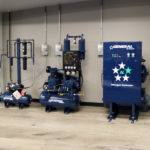 2 blue air compressors and nitrogen generator are sitting next to each other in a room