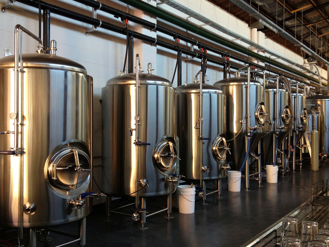 a row of stainless steel tanks in a brewery