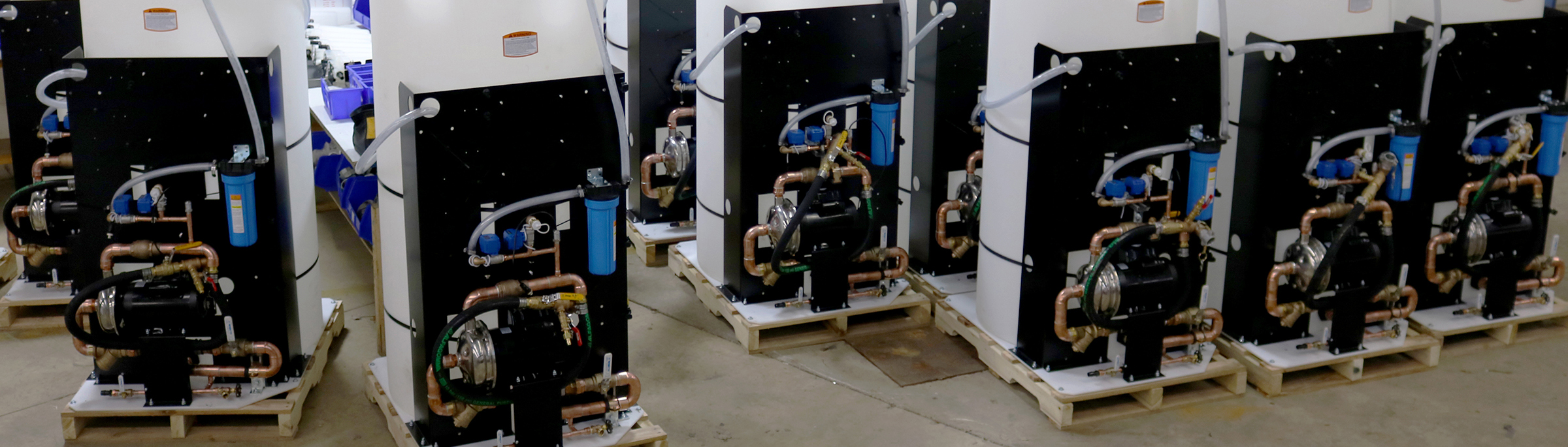 a row of boilers are lined up on wooden pallets