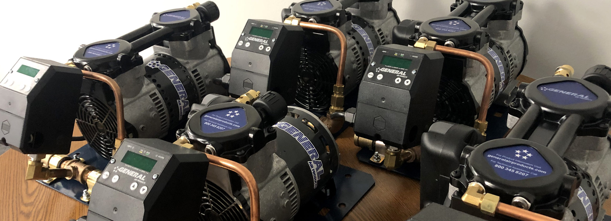 several general compressors are lined up on a table