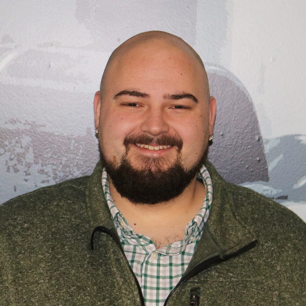 a man with a beard is wearing a green jacket